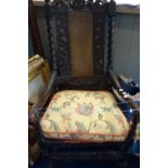 A CHARLES II WALNUT ELBOW CHAIR with later ebonised decoration and a solid seat, the back with a