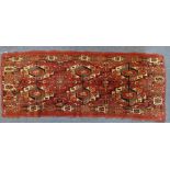 A SMALL RED GROUND PERSIAN RUG, 42cm wide x 105cm long