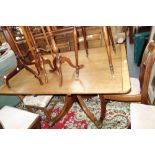 A MAHOGANY BREAKFAST TABLE with brass paw feet