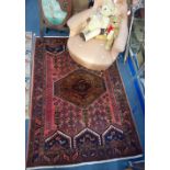 A RED GROUND PERSIAN RUG with allover geometric decoration, 124cm wide x 181cm long