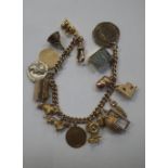 A 9CT GOLD CHARM BRACELET, including two dogs with some charms unmarked, 48.6g