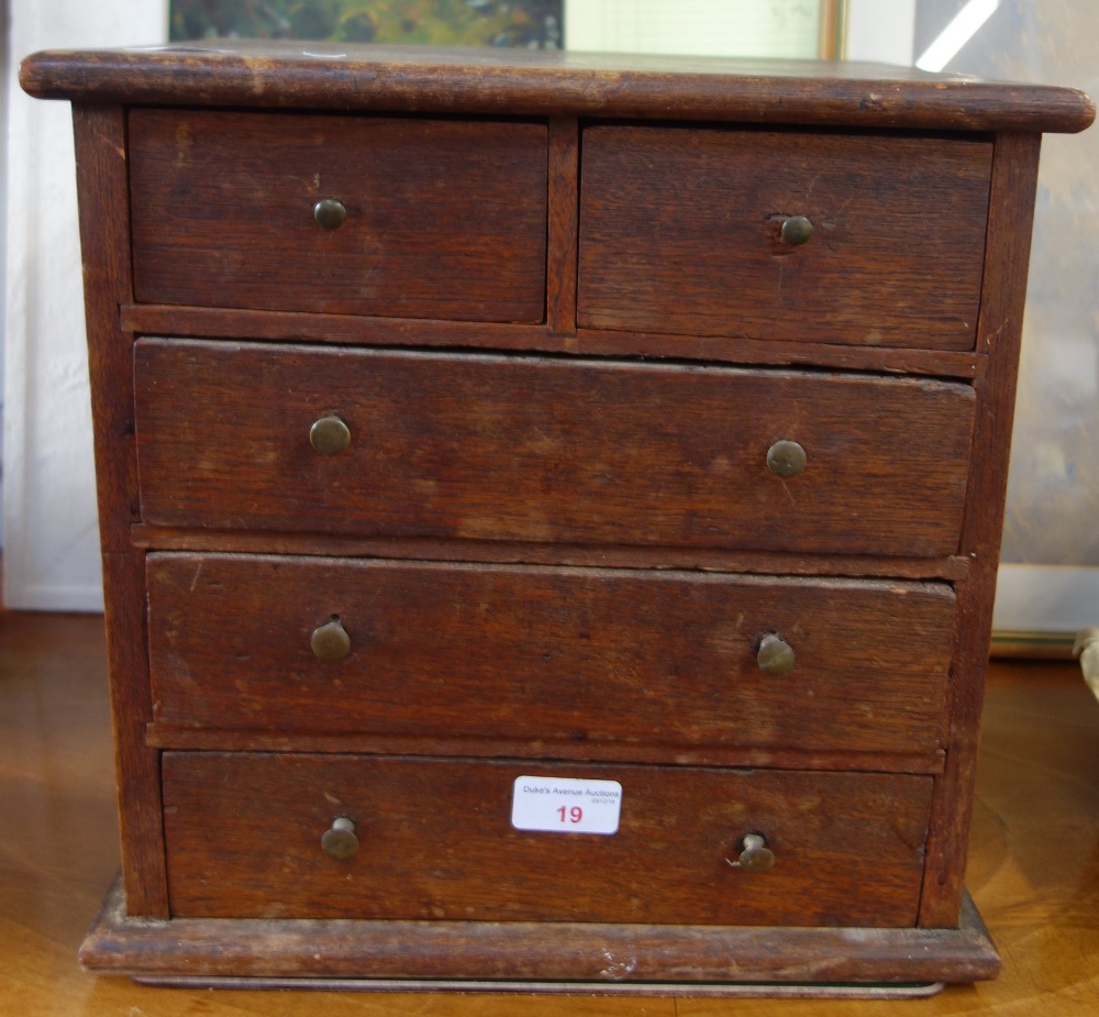 AN OAK MINIATURE CHEST OF DRAWERS, 33.5cm wide