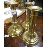 THREE SIMILAR BRASS CANDLESTICKS with ejector mechanisms