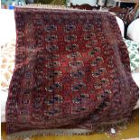 A RED GROUND PERSIAN BOKHARA RUG, 113cm wide x 138cm long (plus fringes, note a pole sleeve