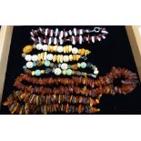 A COLLECTION OF AMBER NECKLACES, including pearL, coral and carved beads