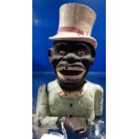 A VINTAGE AMERICAN CAST IRON NOVELTY MONEY BOX in the form of a black man, 21cm high