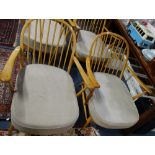 ERCOL; A NEAR PAIR OF PALE BEECH STICK BACK ARMCHAIRS with grey seat cushions
