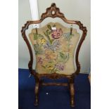 A VICTORIAN WALNUT CHEVAL FIRESCREEN of rococo design with a later floral needlework panel, 61cm
