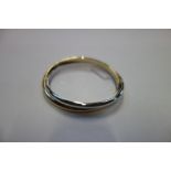 A 9CT WHITE AND YELLOW GOLD HINGED BANGLE, the concealed clasp stamped "375"
