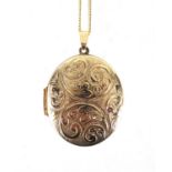 Oval 9ct gold locket with floral chased decoration, on a 9ct gold necklace, the locket 4.5cm in