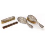 Victorian silver four piece dressing table set including hand mirror, profusely embossed with