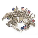 Silver charm bracelet, with a large selection of silver charms including articulated fish, enamelled