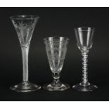Three antique glasses, two with air twist stems and one etched with a rigged ship under a bridge,