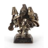 Unmarked Middle Eastern silver figure carrying objects including a guitar, aeroplane, car and cups