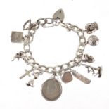 Silver charm bracelet with a selection of mostly silver charms, including rocking horse, crown, duck