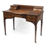 Victorian inlaid mahogany writing desk with tooled leather insert and an arrangement of seven