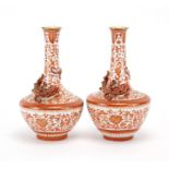 Pair of Chinese porcelain vases decorated in relief with dragons, each hand painted in iron red with