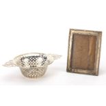 Circular silver twin handled bon bon dish and rectangular silver easel photo frame, both with