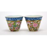 Pair of Chinese porcelain tea cups, each finely hand painted in the famille rose palette with