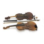 Two old wooden violins, one with bow and carrying case, one violin with one piece back the other