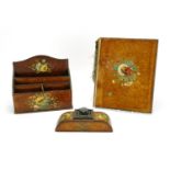 Three piece leather desk set comprising a letter rack, inkwell and blotter, each hand painted with