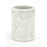 Chinese Blanc de Chine porcelain brush pot, finely decorated in relief with Qilin lions amongst