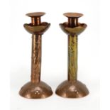 Pair of Arts & Crafts copper candlesticks by Newlyn, each embossed with three stylised fish,