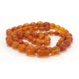 Amber coloured fasciated graduated bead necklace, 86cm in length, approximate weight 50.6g : For