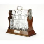 Mahogany tantalus with silver plated mounts housing three cut glass decanters, 34cm high : For Extra