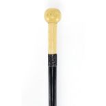 Ebonised walking stick with turned marine ivory pommel and silver collar, indistinct London