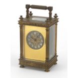 French brass cased carriage clock with architectural columns, silvered chapter ring and Arabic