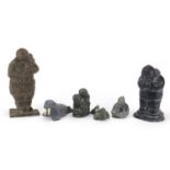 Five Inuit figures including four stone carvings and a large bronzed Eskimo, some with paper labels,