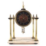 French brass drum clock striking on a gong with visible Brocot escapement, raised on four reeded