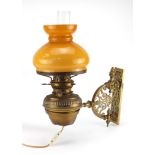 Victorian ornate pierced brass wall bracket with Hinks patent oil lamp, with glass shade and funnel,