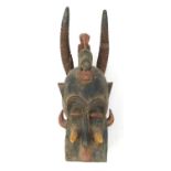 Large tribal carved wood dragon face mask with green and red painted decoration, 57cm high : For