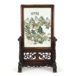 Chinese hardwood table screen housing a porcelain panel hand painted with figures in a river