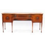 Inlaid mahogany serpentine front sideboard with brass lion mask handles, raised on tapering legs,