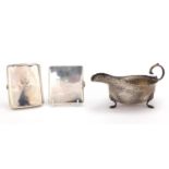 Silver three footed sauce boat and two rectangular silver cigarette cases, various hallmarks, the