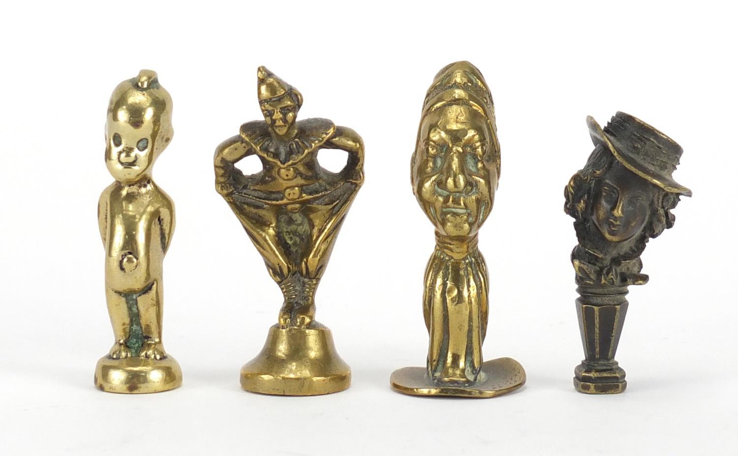 Four antique pipe tampers including a pierrot design example, the largest 7cm high : For Further