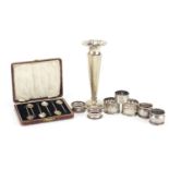 Silver items including a trumpet bud vase, napkin rings, set of six coffee bean spoons and two