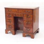 Victorian mahogany kneehole desk fitted with an arrangement of eight drawers and central cupboard