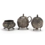 Indian unmarked silver three piece cruet, embossed with flowers, the largest 5.5cm high, approximate