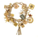 9ct gold charm bracelet with a large selection of mostly 9ct gold charms including bird in a cage,