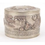 Indian unmarked silver cylindrical box and cover embossed with figures in a village, 7cm high x