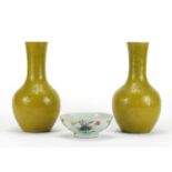 Pair of Chinese yellow glazed vases and a famille rose footed bowl hand painted with flowers, the