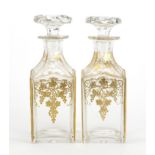 Pair of 19th century continental glass decanters, gilded with leaves and berries, each 20.5cm high :