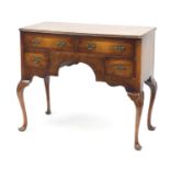 Walnut and mahogany cross banded low boy, fitted with four drawers on shell carved cabriole legs,