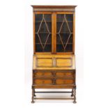 Edwardian Oak bureau bookcase with pair of glazed doors enclosing three shelves above a fall, with