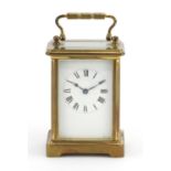 French brass cased carriage clock with travelling case, the clock with enamelled dial and Roman