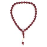 Islamic cherry amber coloured bead prayer necklace, overall 48cm in length, the largest bead